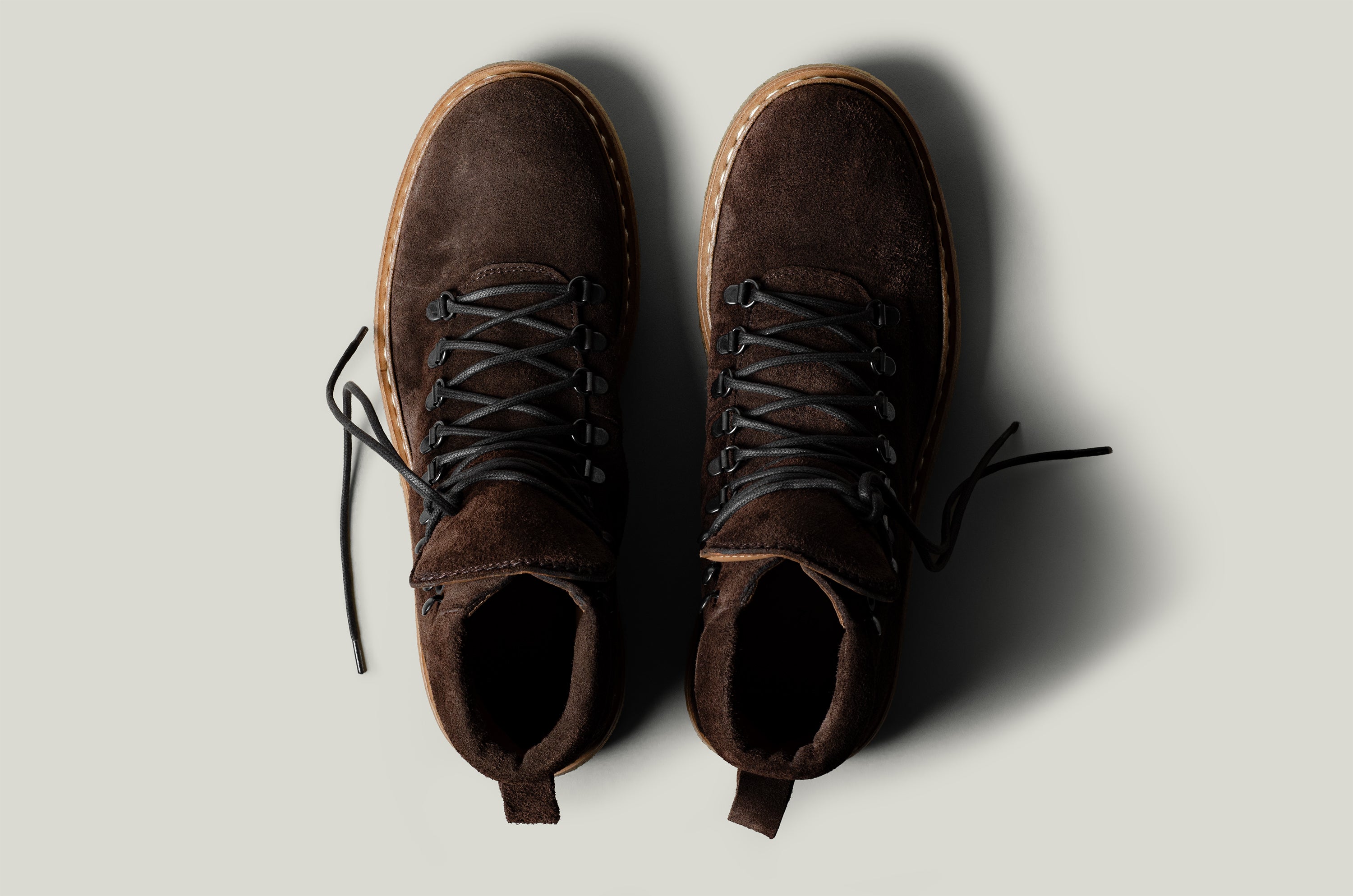 Pair of brown suede boots on a light gray background