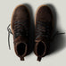 Pair of brown suede boots on a light gray background