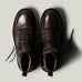 Brown leather hike boots on light grey background.