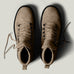 Pair of brown leather boots on a light gray background