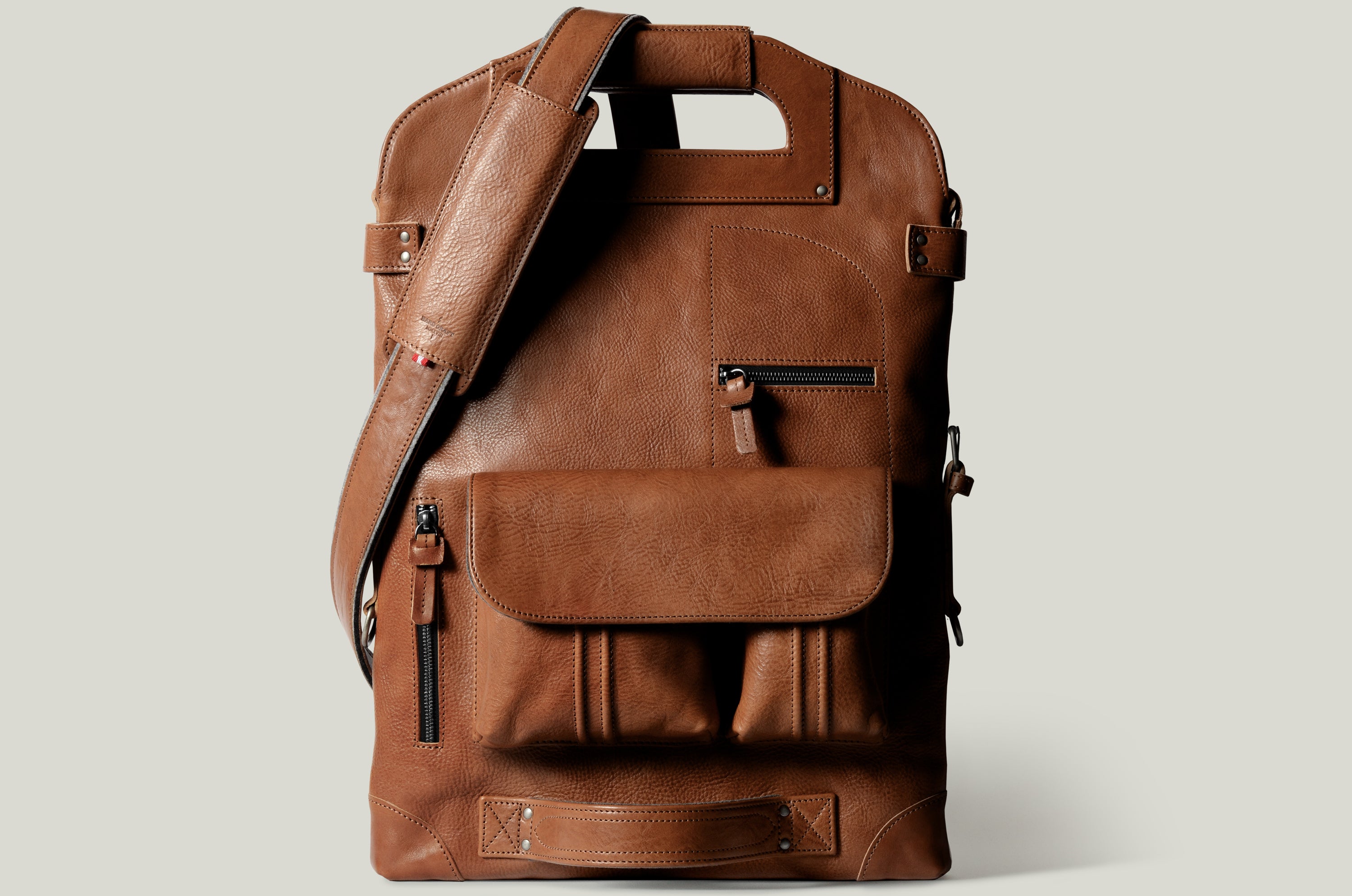 Brown leather backpack on a light gray background
