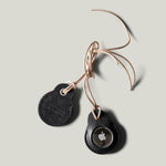 A pair of black leather Apple airtag holders on light grey background
