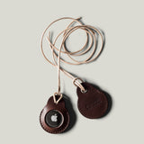 A pair of dark brown apple airtag holders on a light grey background