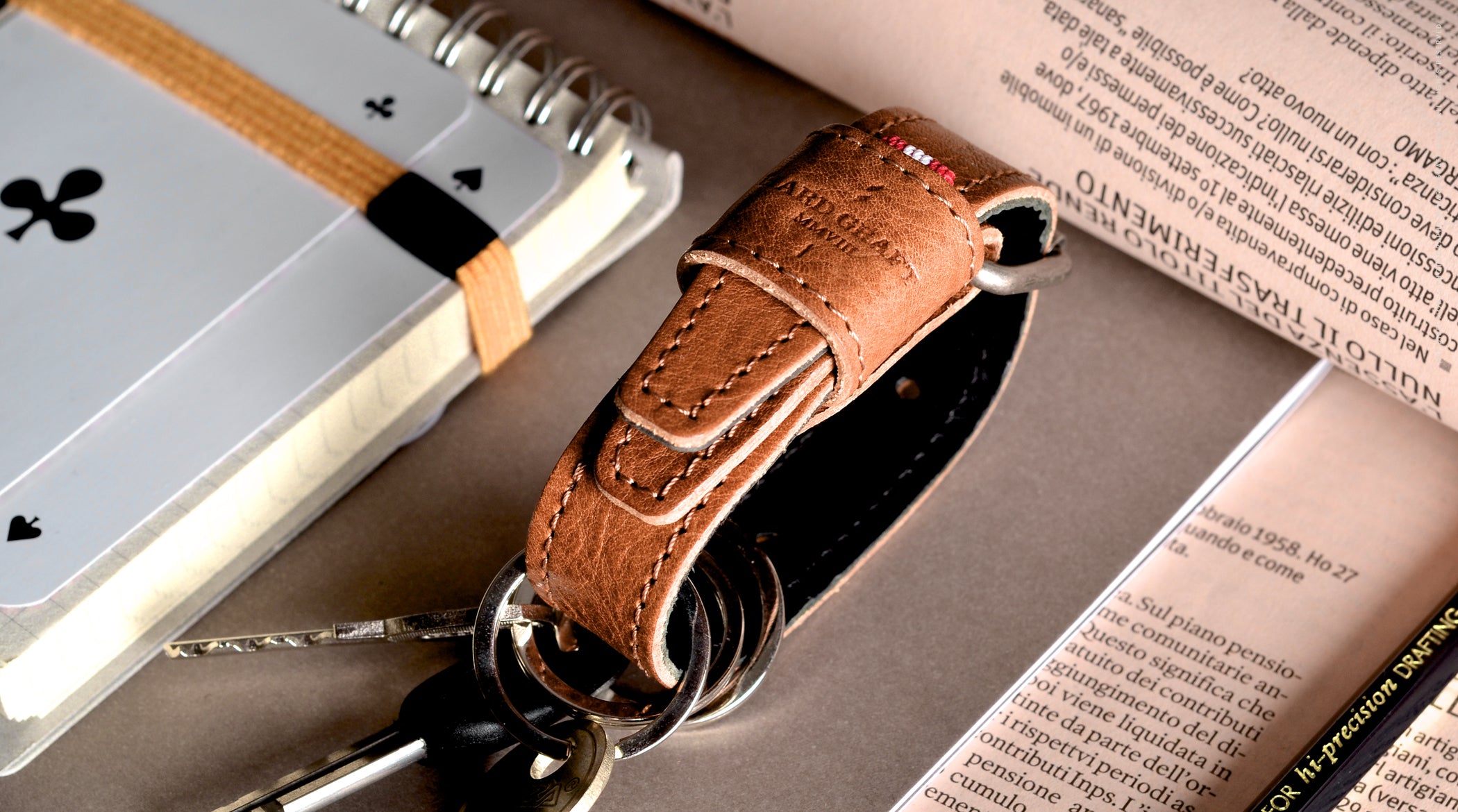 Brown leather key belt on busy background.