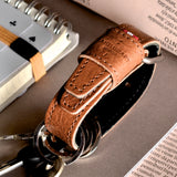 Brown leather key belt on busy background.
