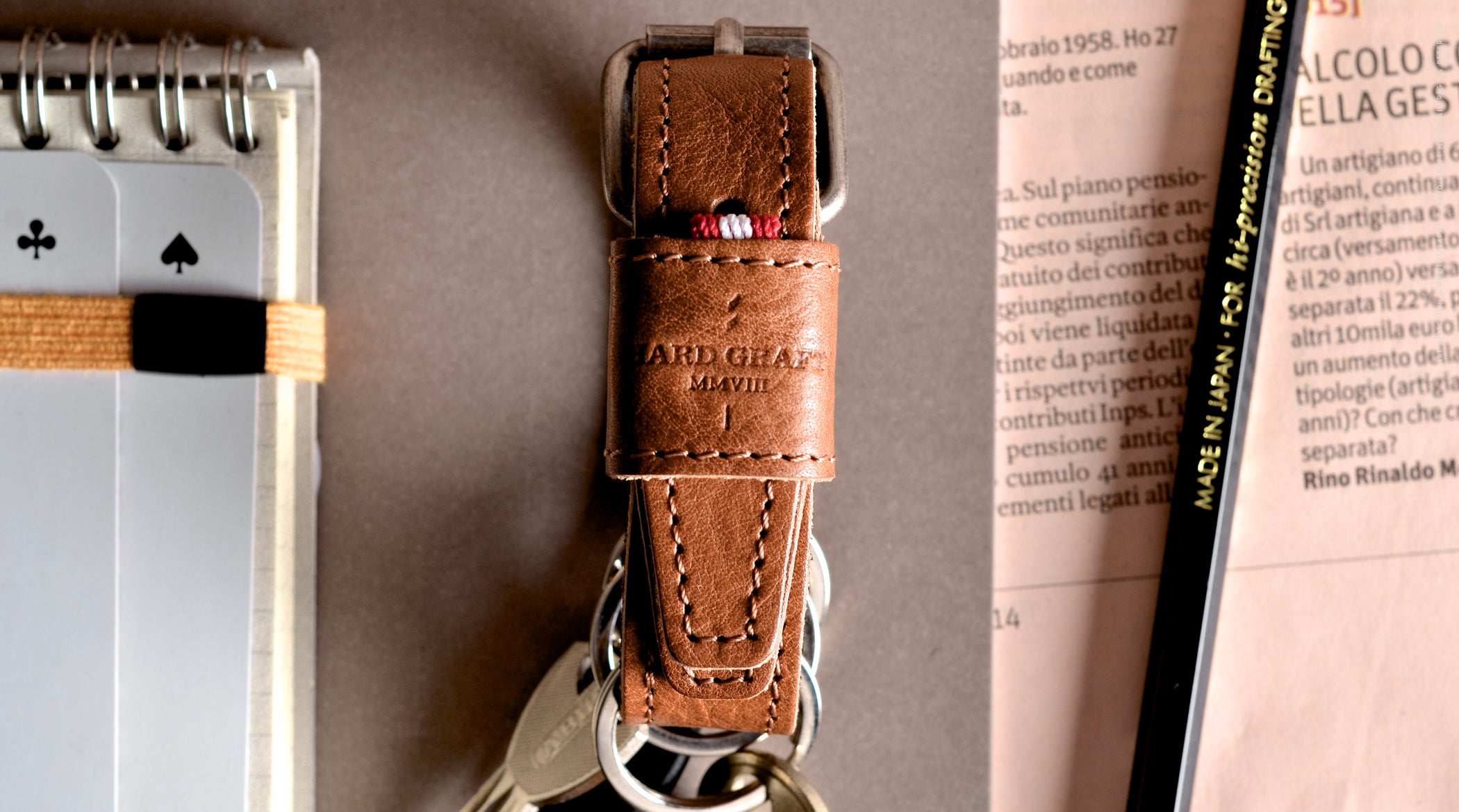 Brown leather key belt on busy background.