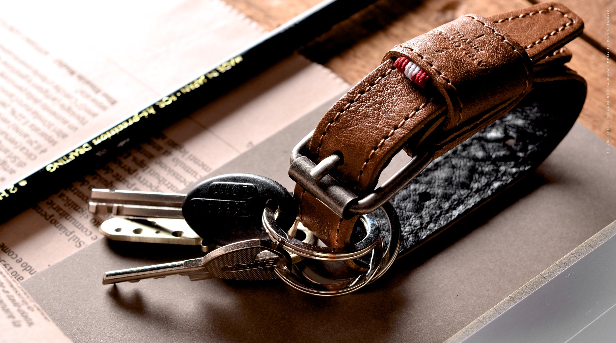 Brown leather key belt on busy background.