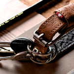 Brown leather key belt on busy background.