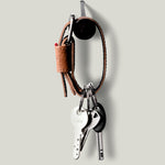 Brown leather key belt on light background.