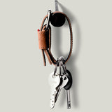 Brown leather key belt on light background.