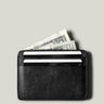 Black card case with money and cards on a light gray background