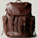 Brown leather backpack on a light gray background