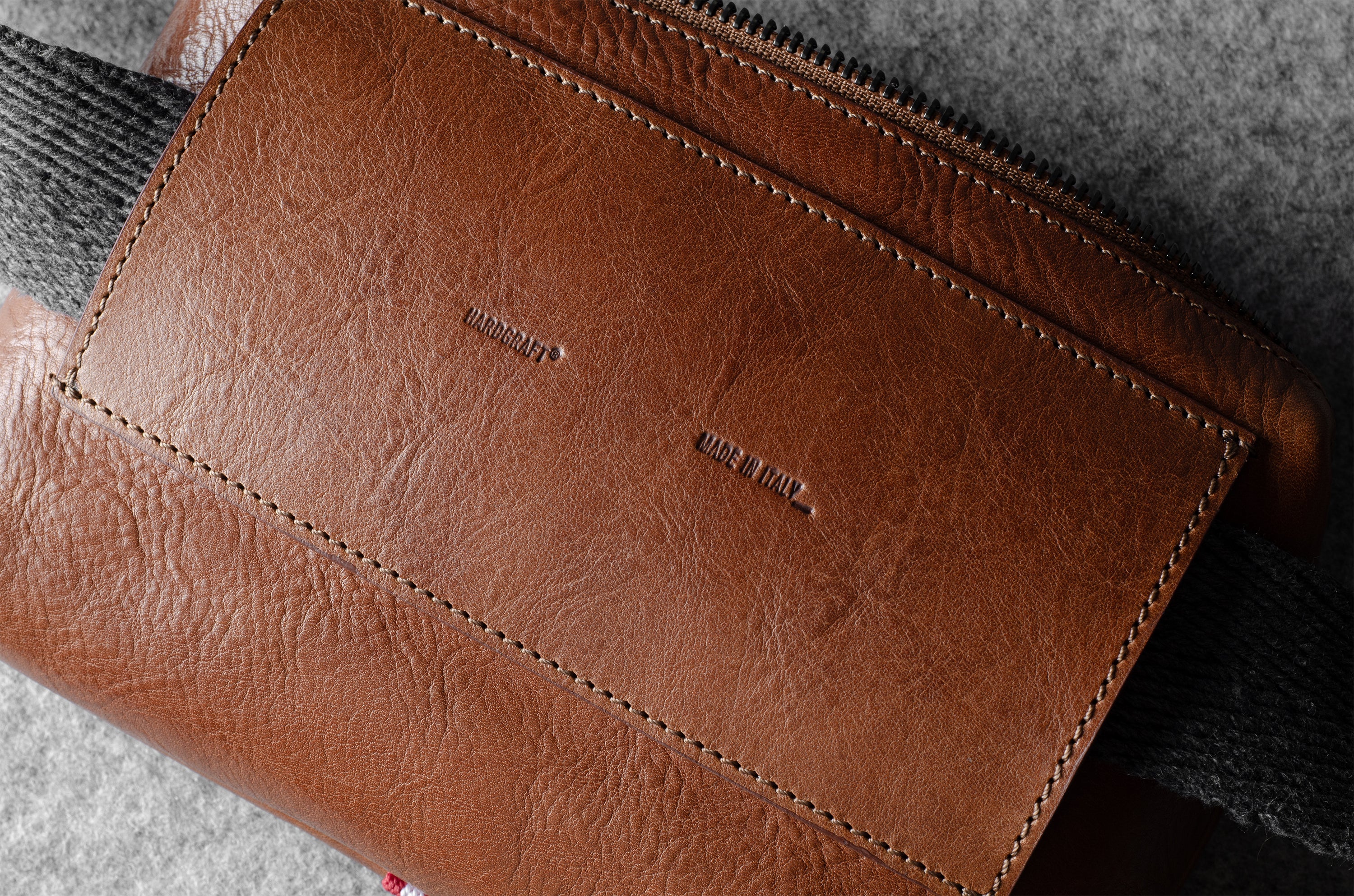 Brown leather bag with visible hardgraft brand name on a textured surface