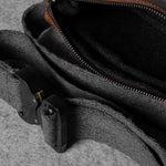 Brown leather bag with a strap on a gray surface