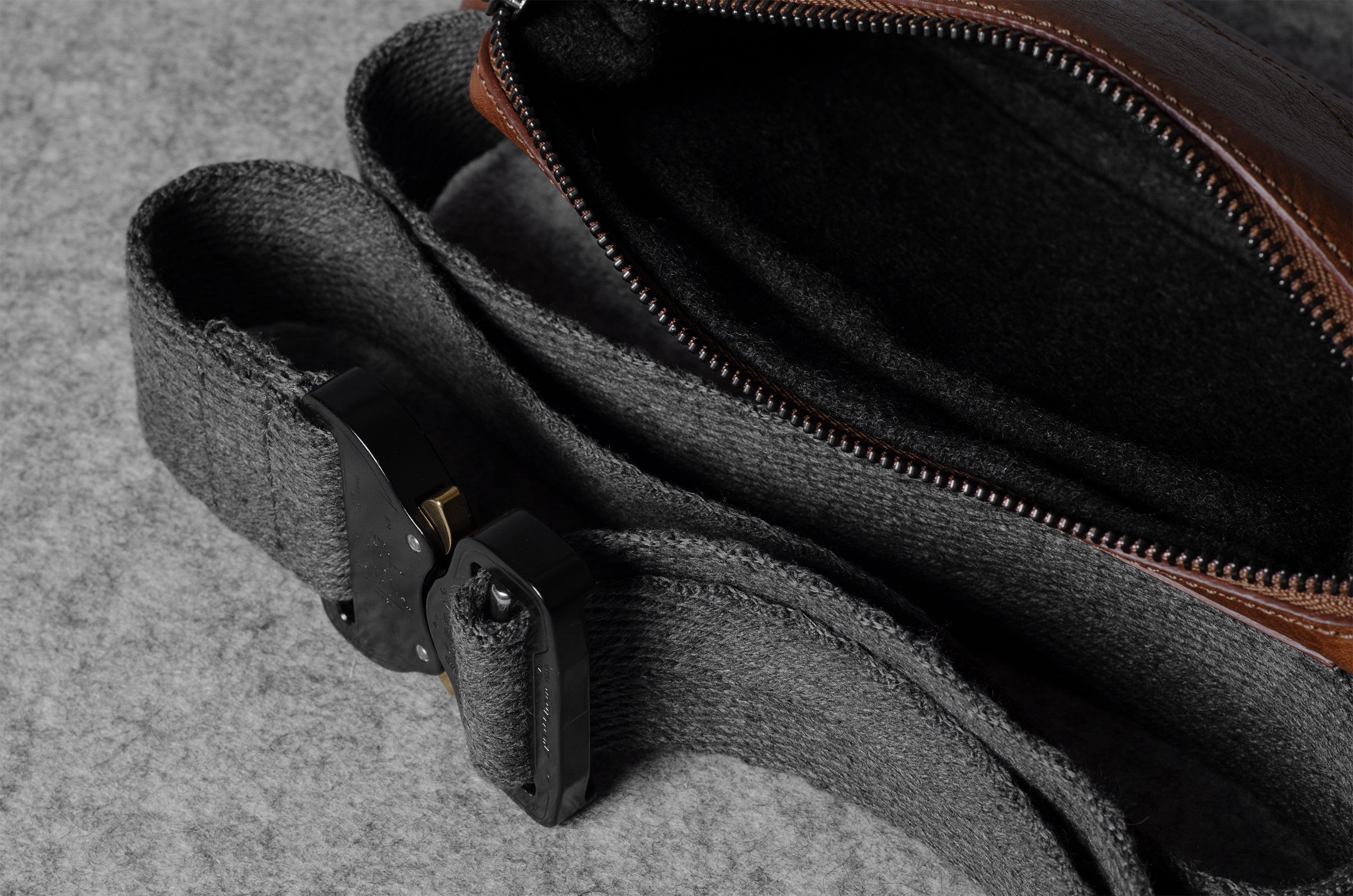 Brown leather bag with a strap on a gray surface