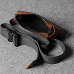 Gray waist bag with brown leather patch on a gray background