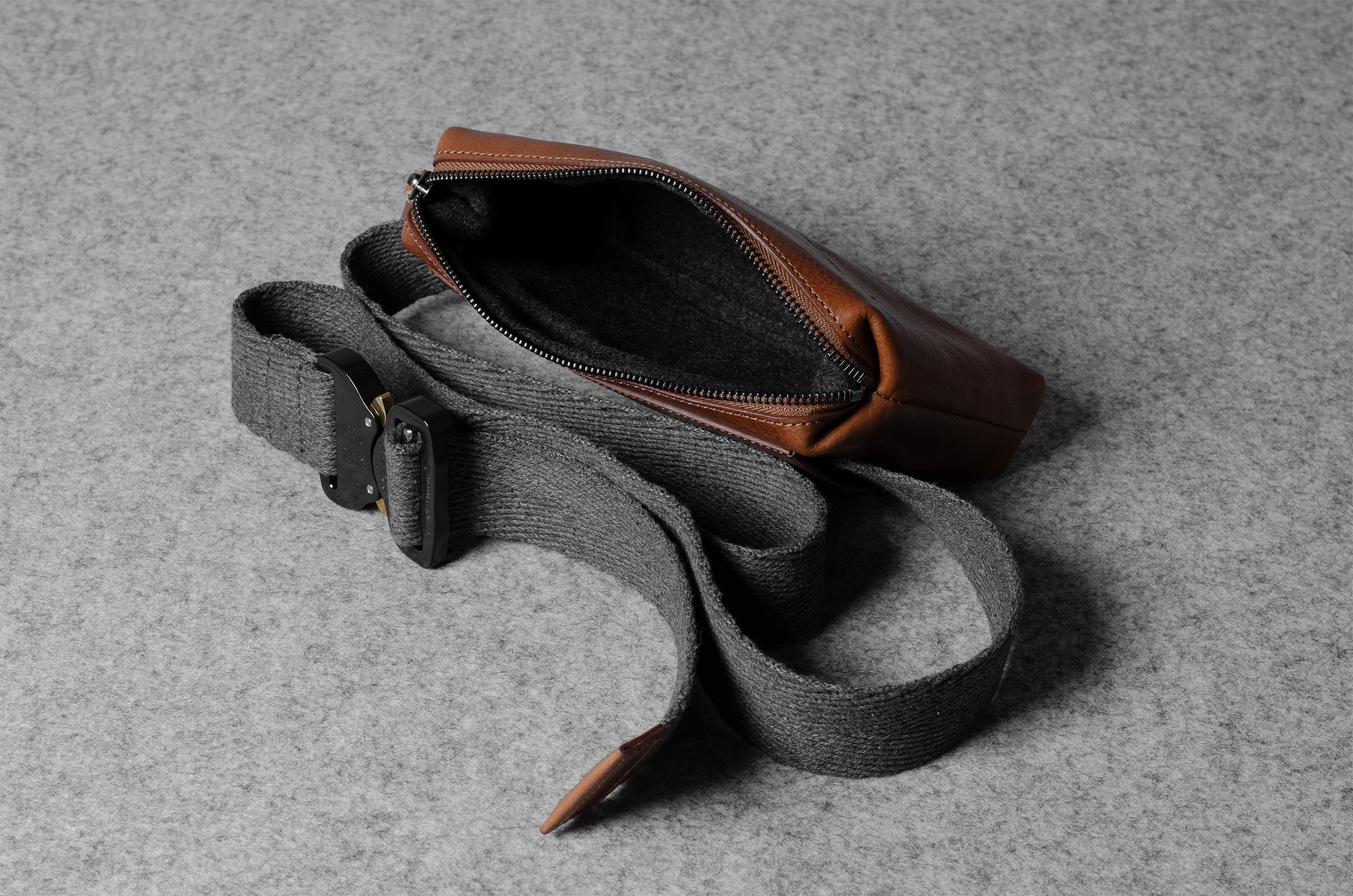 Gray waist bag with brown leather patch on a gray background