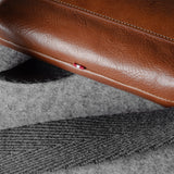 Brown leather bag on a textured gray fabric surface