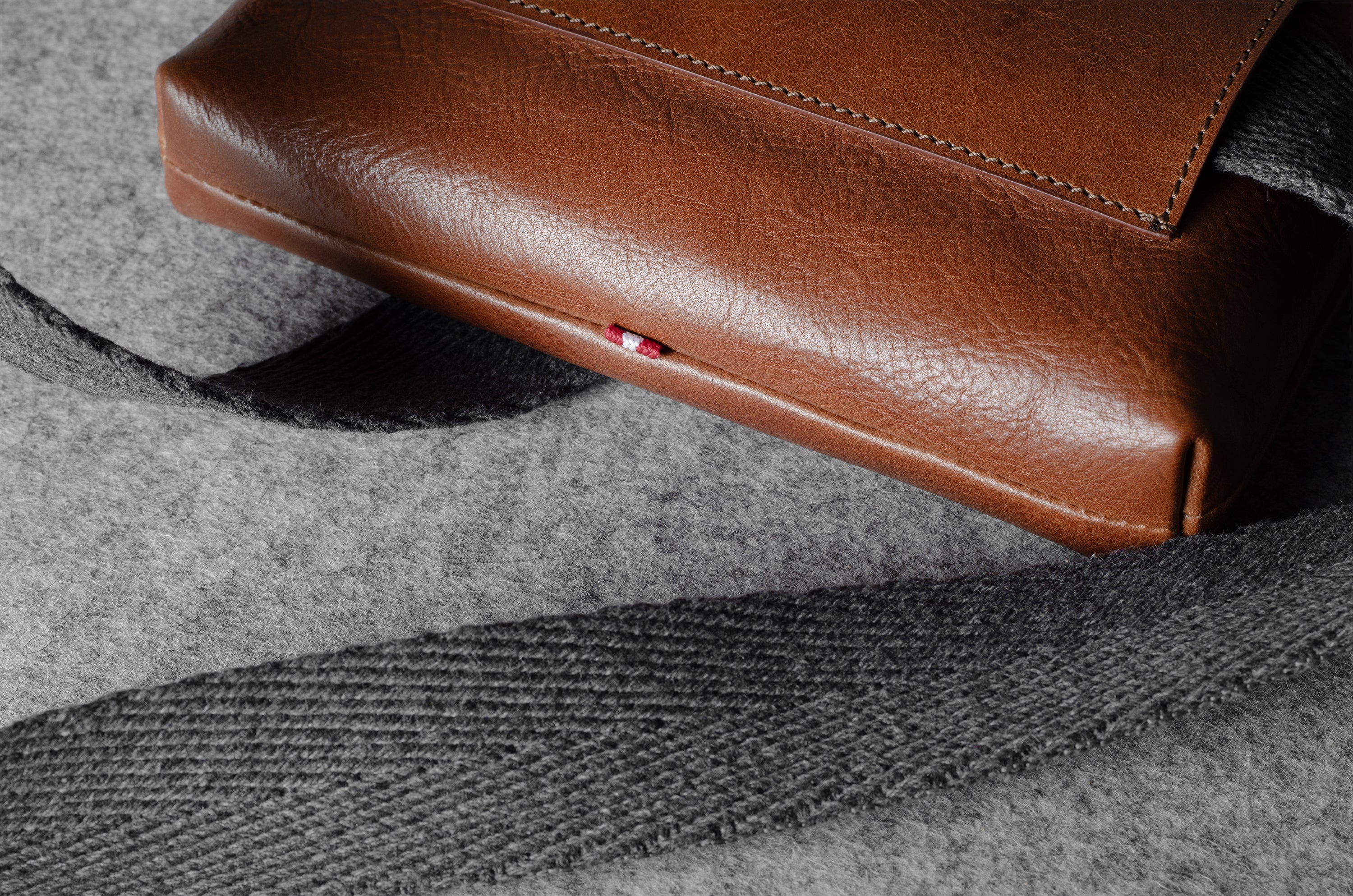 Brown leather bag on a textured gray fabric surface