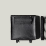 Black leather bag on a light gray background