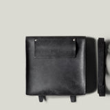 Black leather bag on a light gray background