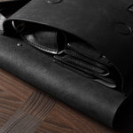 Black leather bag on a wooden surface