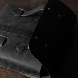 Black leather bag on a wooden surface