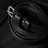 Black leather belt on a black surface