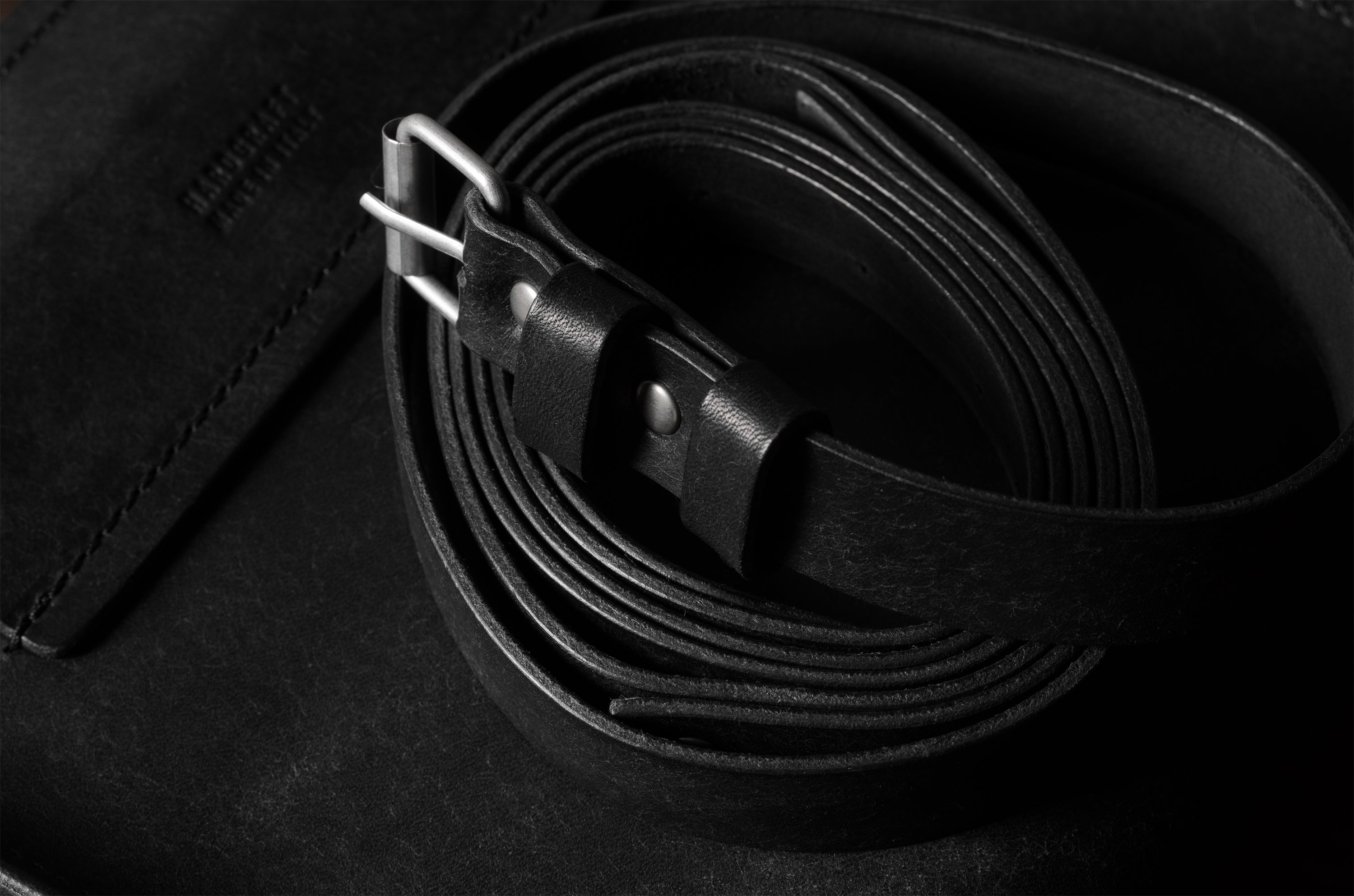 Black leather belt on a black surface