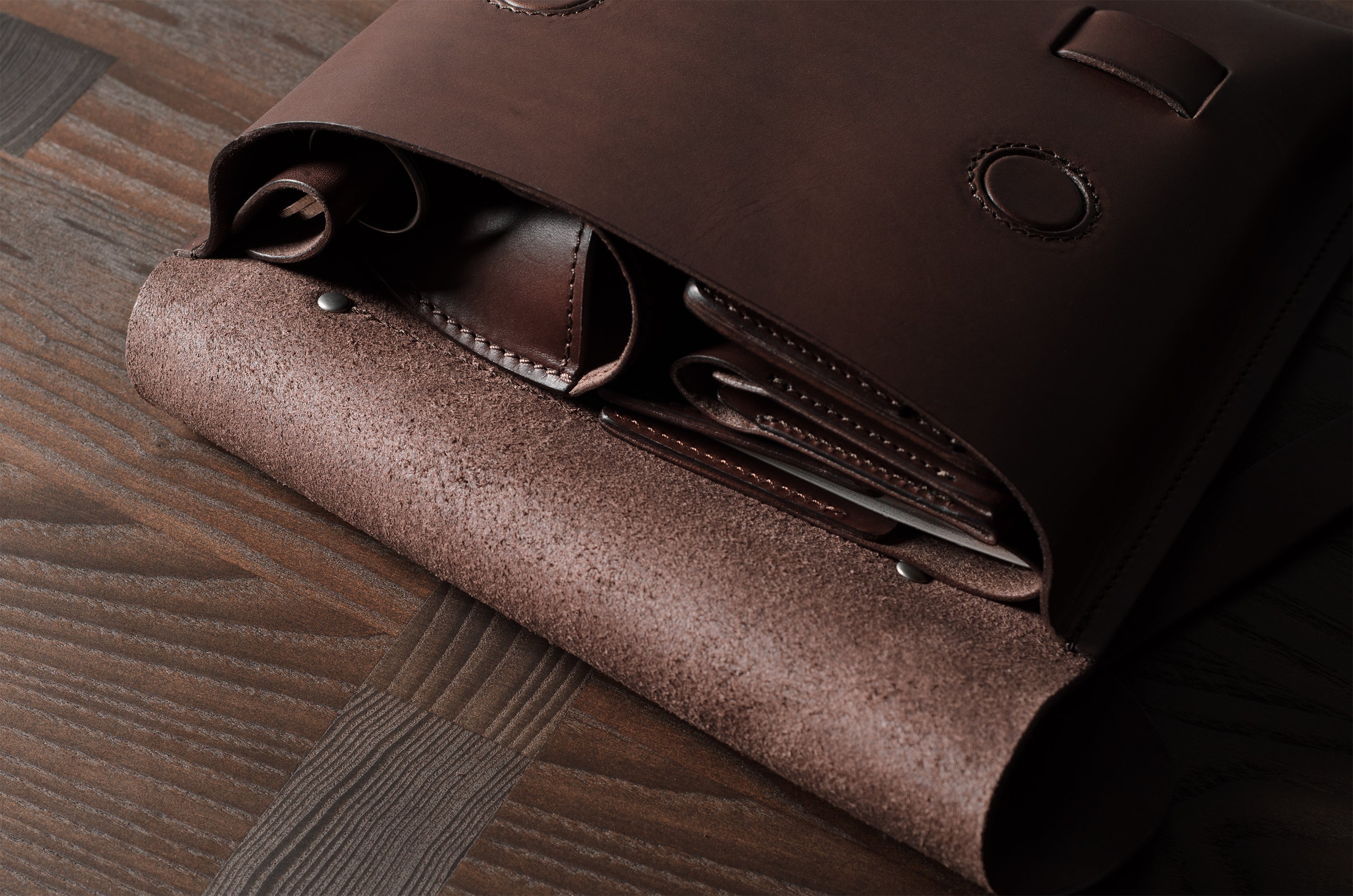 Close-up of a brown leather bag on a wooden surface