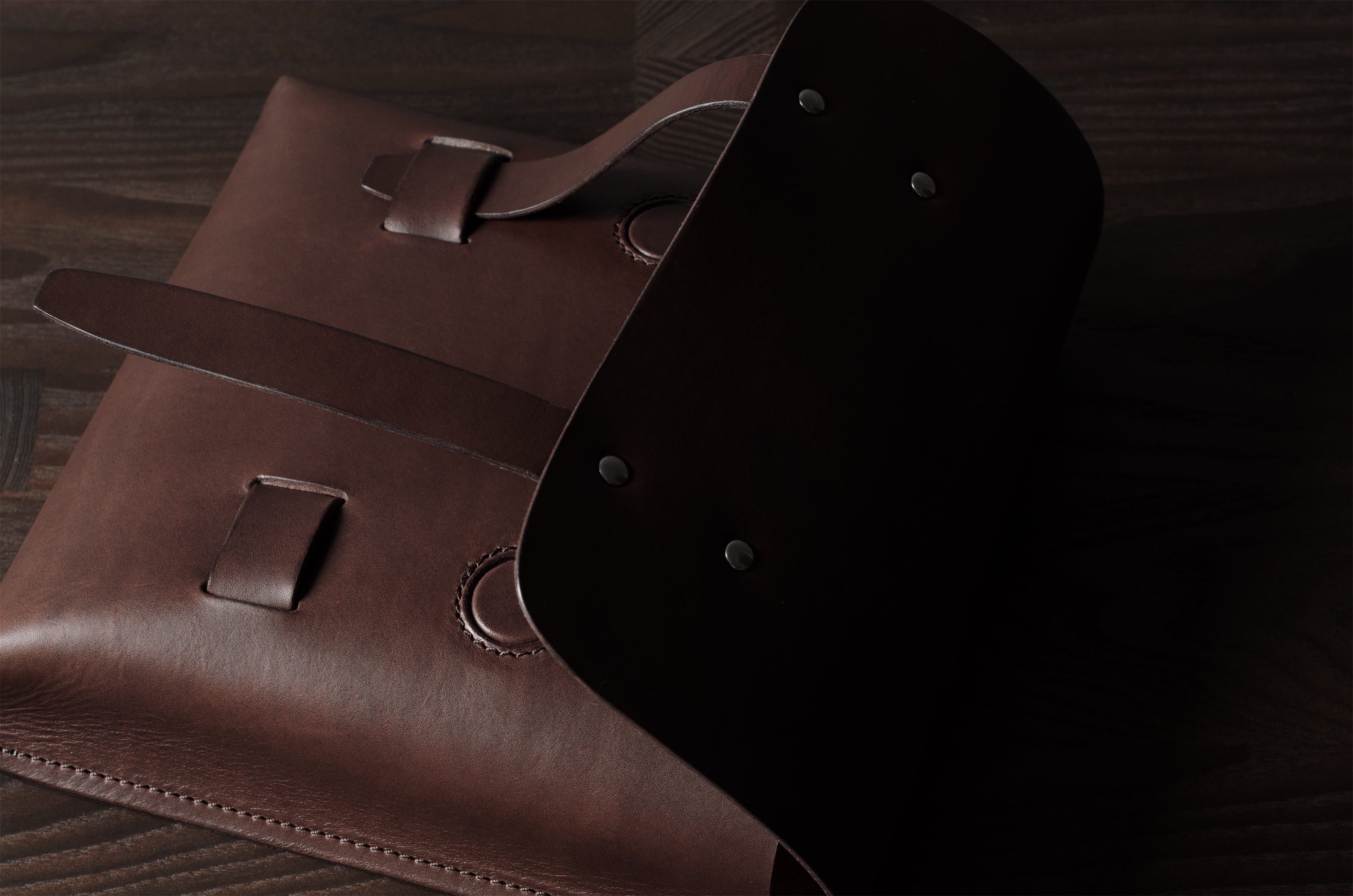 Brown leather bag on a wooden surface