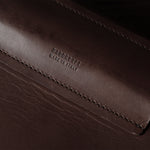 Close-up of a brown leather product with branding.