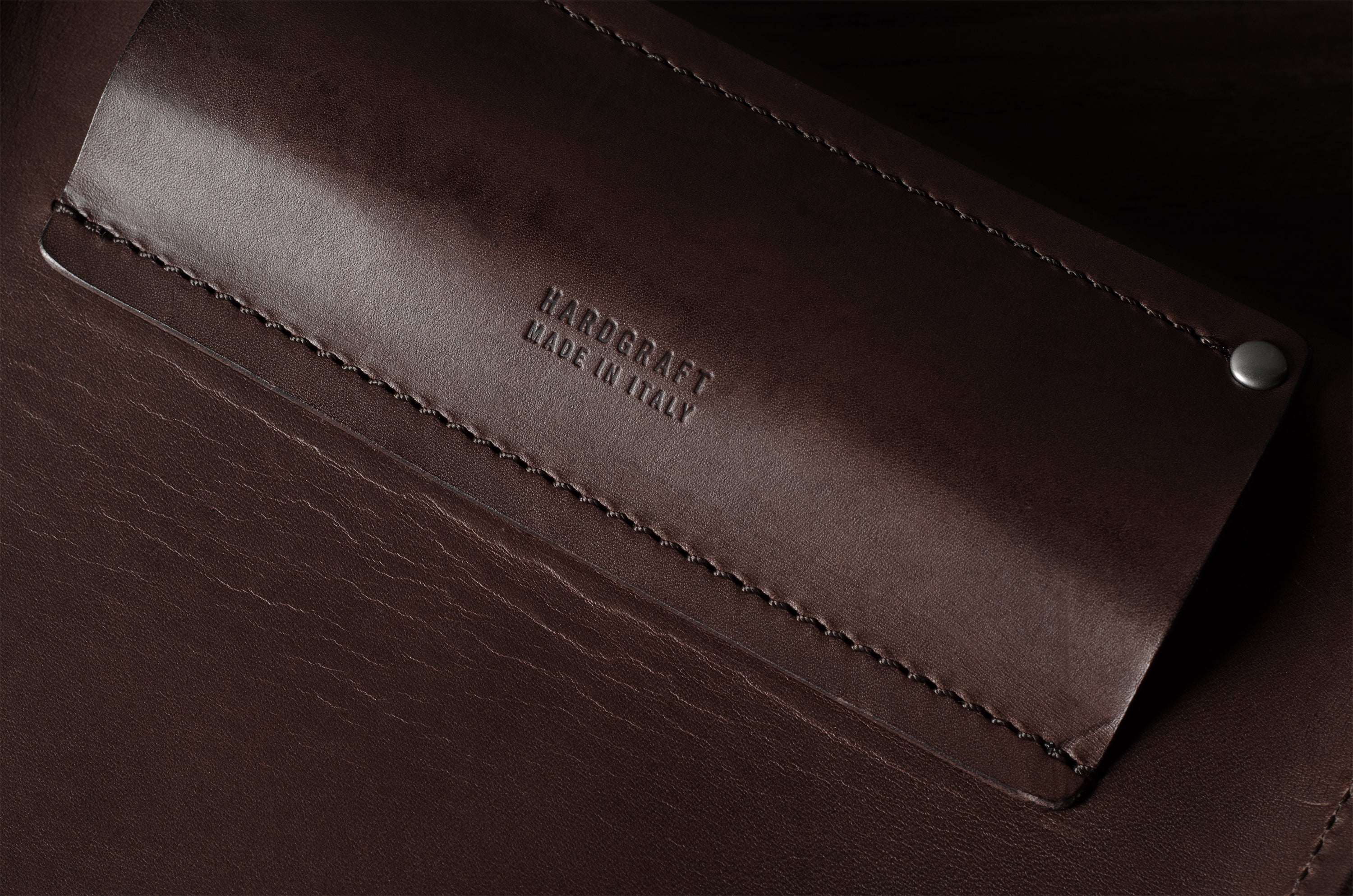 Close-up of a brown leather product with branding.