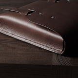 Brown leather bag on a wooden surface