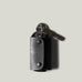 Black leather key holder with 2 metal buttons on light grey background