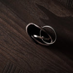 Dark brown leather key holder with keyring and key on wood background