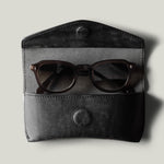 Black leather glasses case with sunglasses inside
