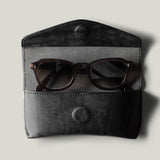 Black leather glasses case with sunglasses inside