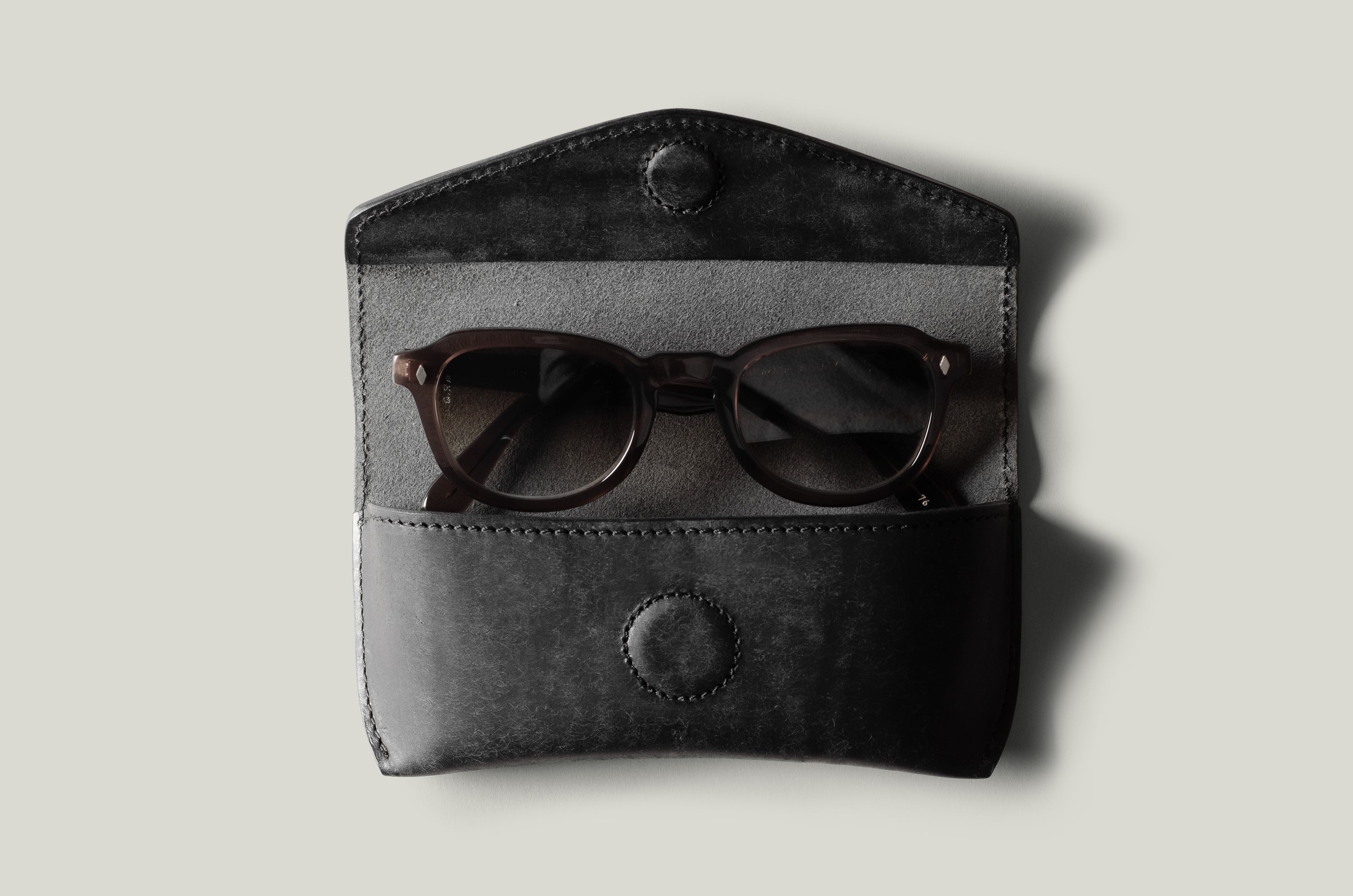 Black leather glasses case with sunglasses inside