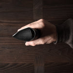 Black leather glasses case in hand