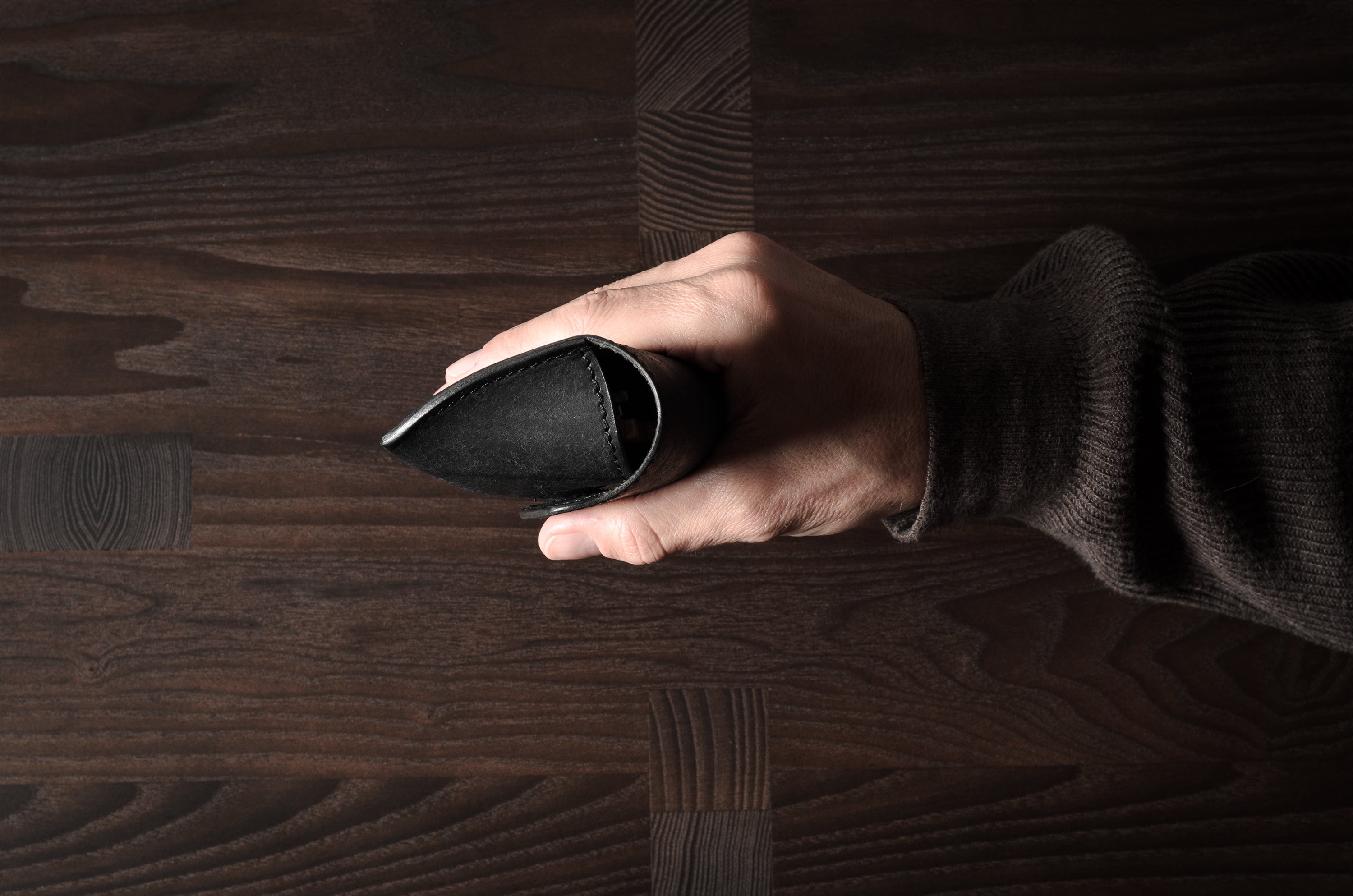 Black leather glasses case in hand