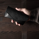Black leather glasses case in hand