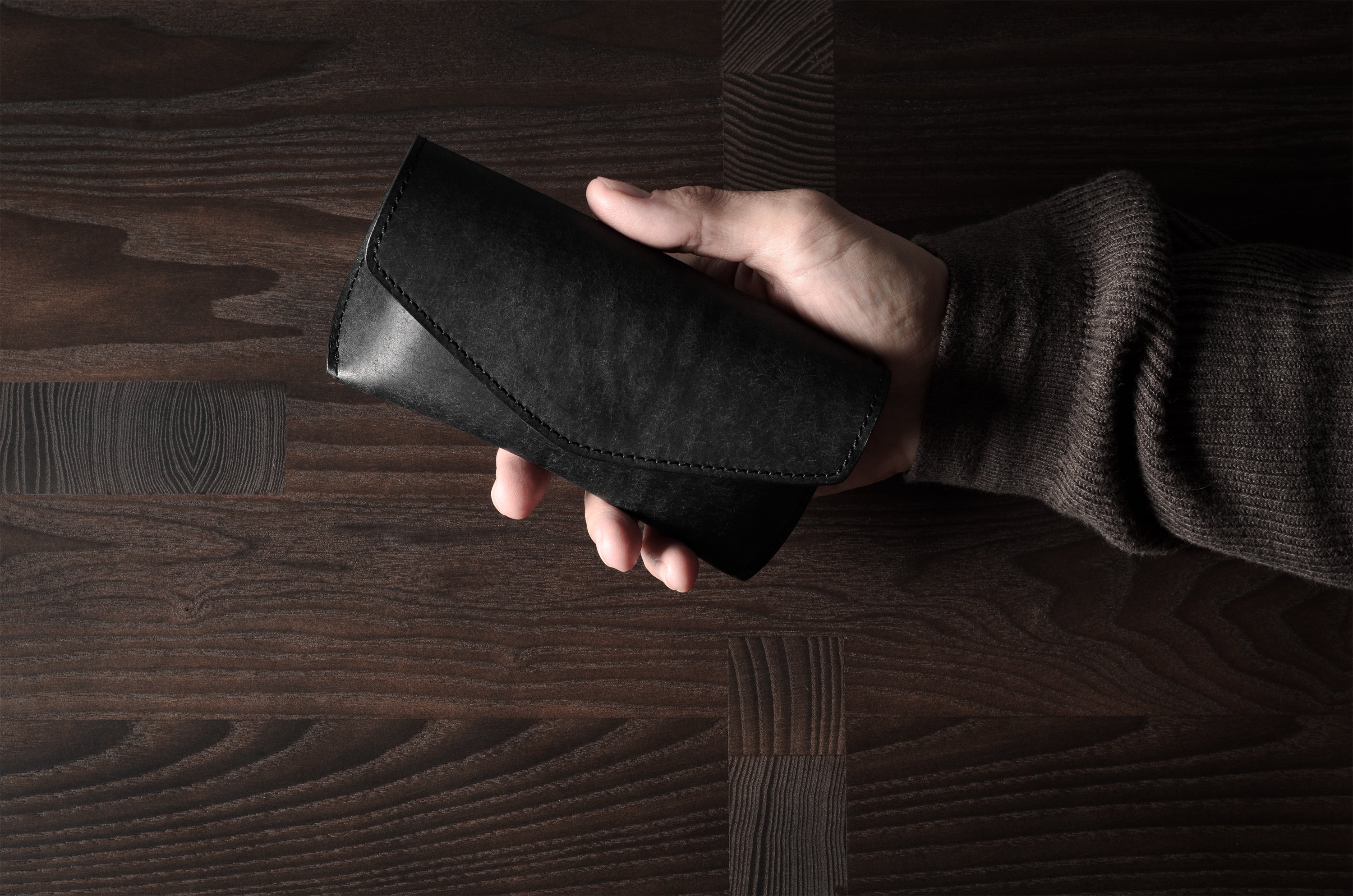 Black leather glasses case in hand