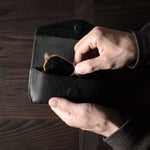 Black leather glasses case with sunglasses in hand