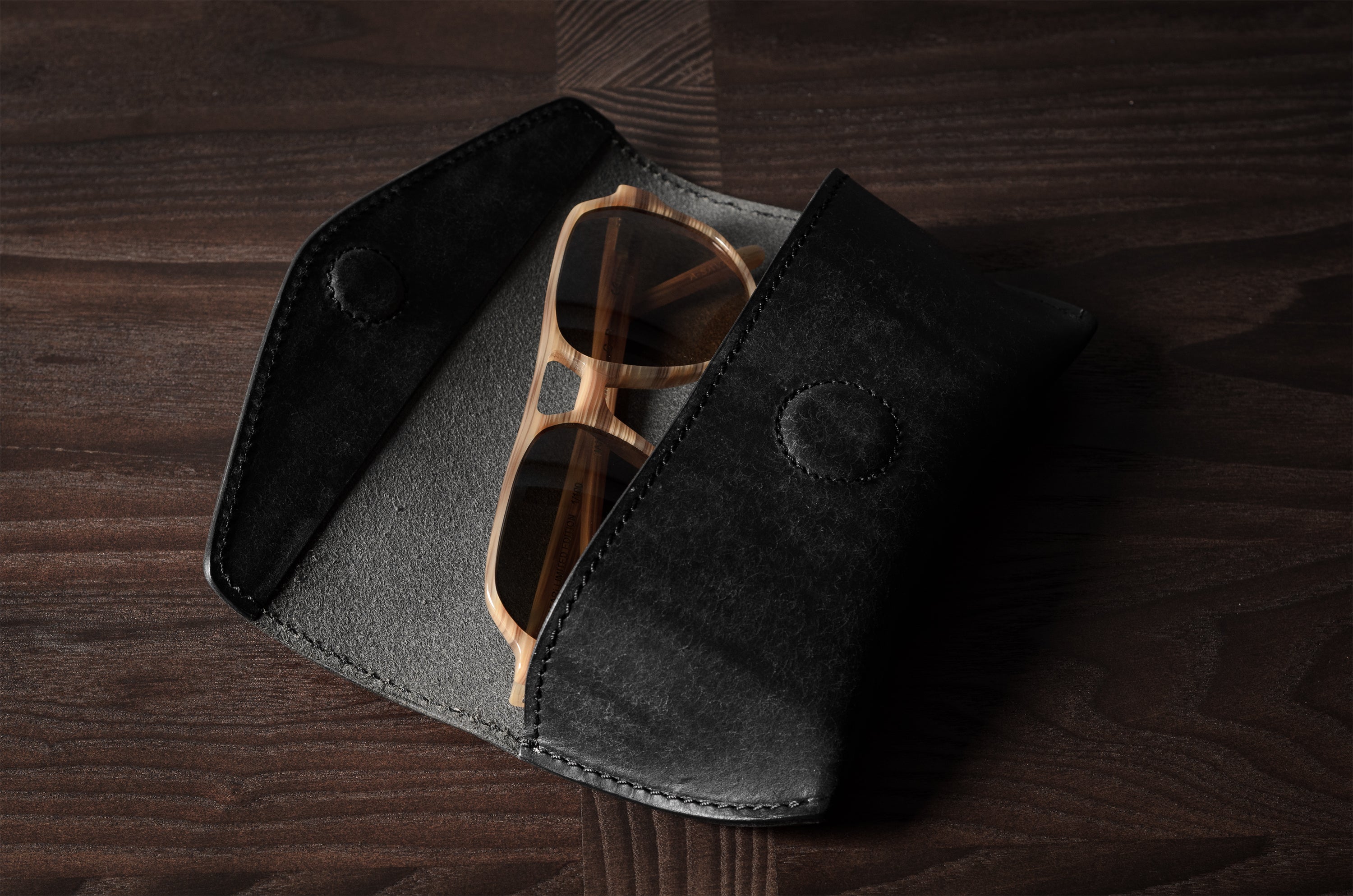 Black leather glasses case with sunglasses