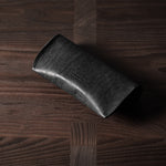 Black leather glasses case on wood background