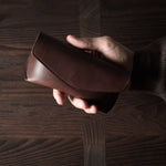 Dark brown leather glasses case in hand