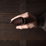 Dark brown leather glasses case in hand