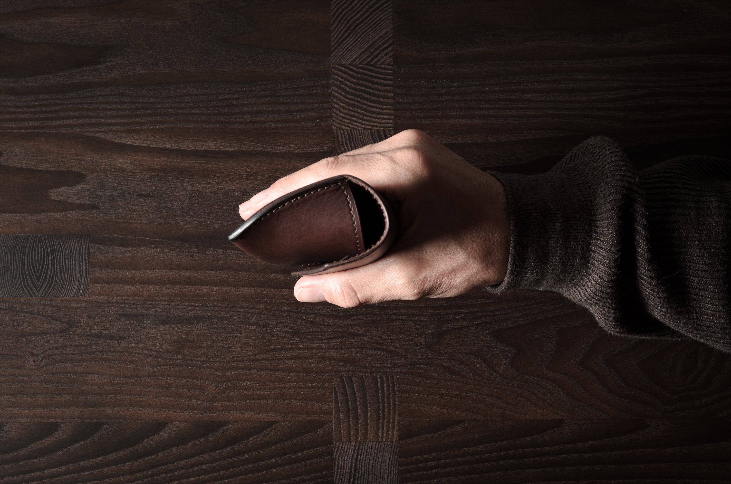Dark brown leather glasses case in hand