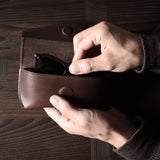 Dark brown leather glasses case in hand